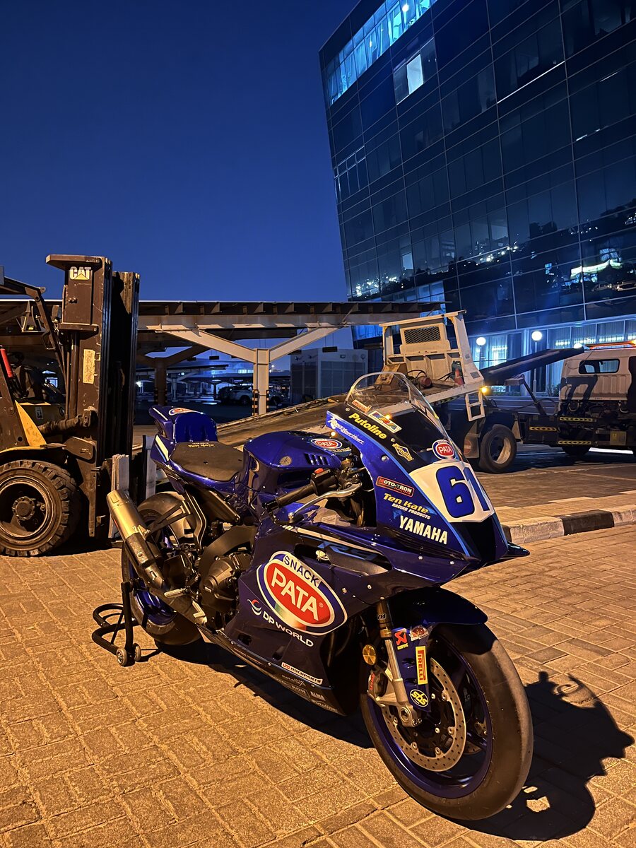 Pata Yamaha World Superbike race bike in DP World livery on a forklift at night